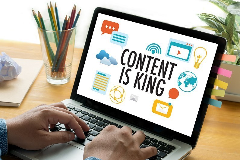 Person's hands on a laptop displaying content is king to represent content as part of a B2B inbound marketing growth plan